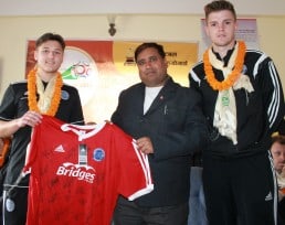 Striker Ashley Bayliss (left) and Captain Ben Hutchings (right) present a signed ATFC shirt to Sahara Club President Bir Bhadra Acharya